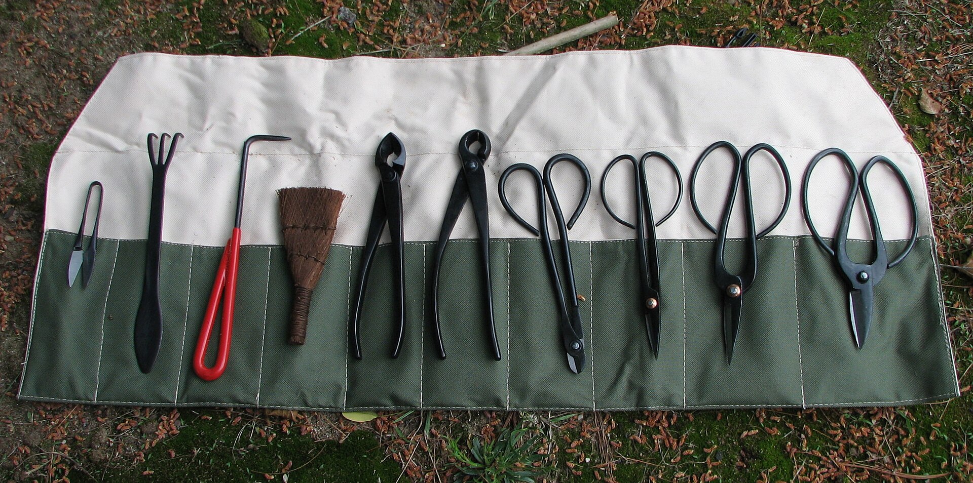 Aufgerollte Bonsai-Werkzeugtasche mit verschiedenen Bonsai-Werkzeugen