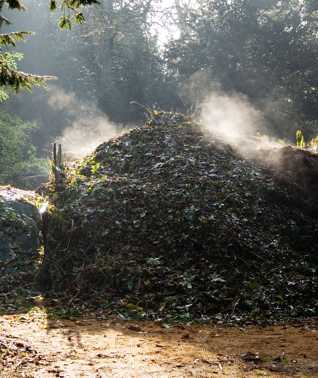 Ein offener Komposthaufen mit organischem Material im Garten